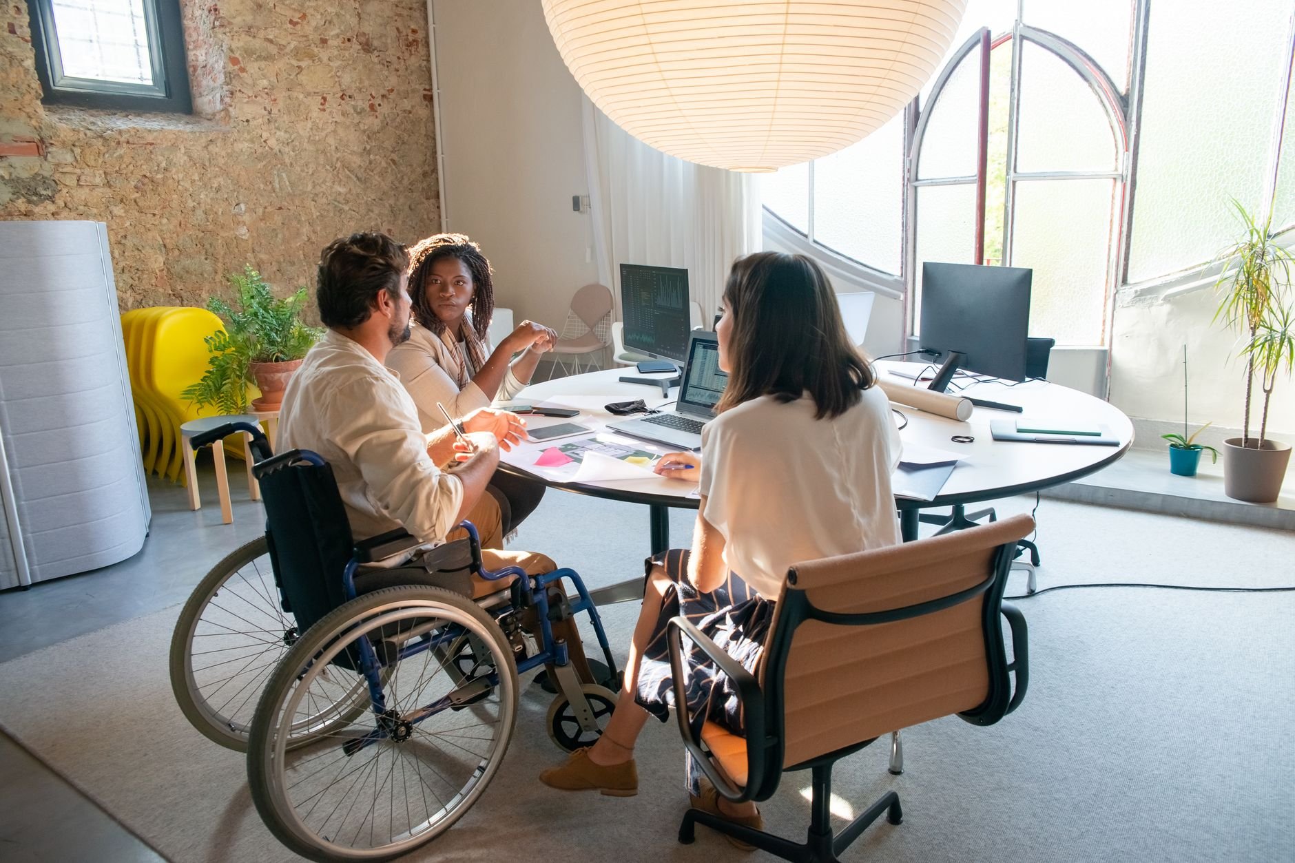 A diverse group of coworkers collaborating at a workspace, representing the inclusive community at Elevar.